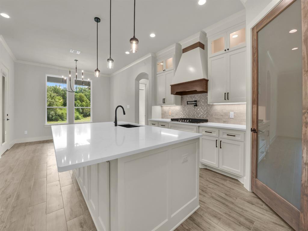 313 Wrangler Court Weatherford, TX 76088 - Photo 22 of 40 a kitchen with kitchen island white cabinets and stainless steel appliances