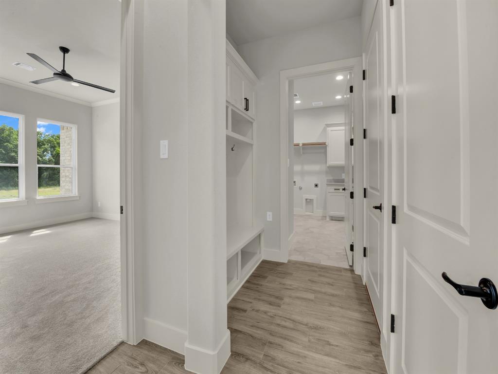 313 Wrangler Court Weatherford, TX 76088 - Photo 26 of 40 a view of a hallway with wooden floor and a bathroom