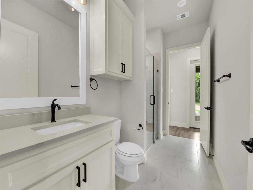 313 Wrangler Court Weatherford, TX 76088 - Photo 39 of 40 a bathroom with a sink a toilet and shower