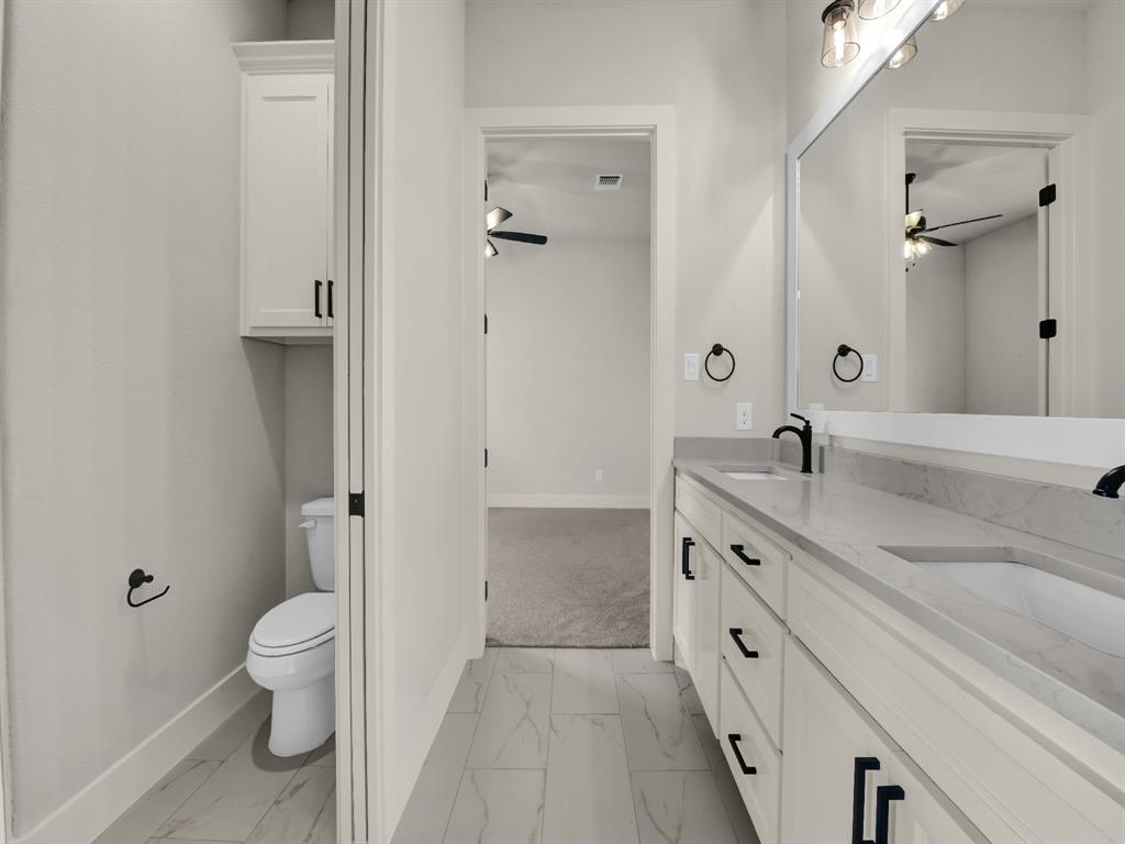 313 Wrangler Court Weatherford, TX 76088 - Photo 40 of 40 a spacious bathroom with a granite countertop sink a toilet and a large mirror