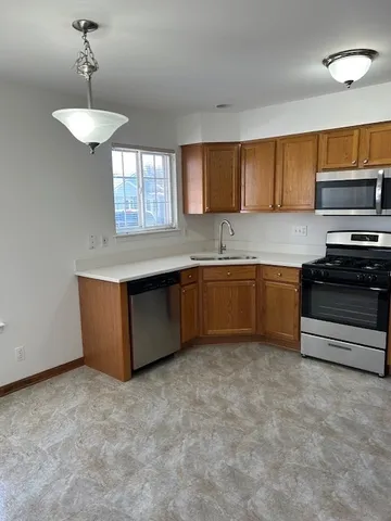 a kitchen with stainless steel appliances granite countertop a sink a stove and a refrigerator