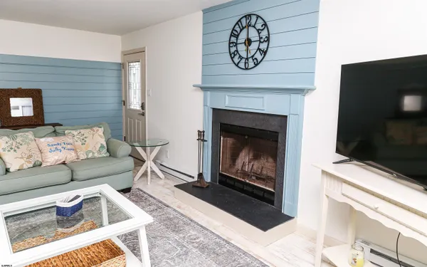 a living room with furniture a flat screen tv and a fireplace