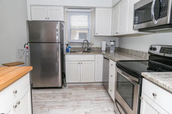 a kitchen with a refrigerator sink stove and cabinets