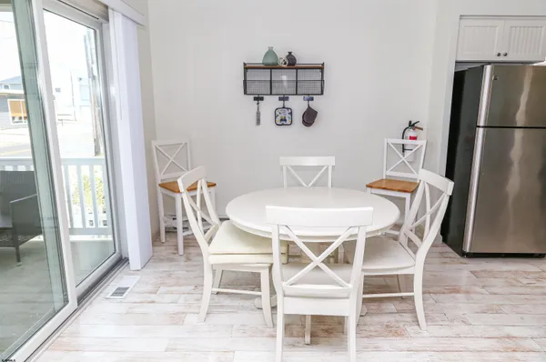a kitchen with stainless steel appliances a refrigerator a stove a sink and a dining table