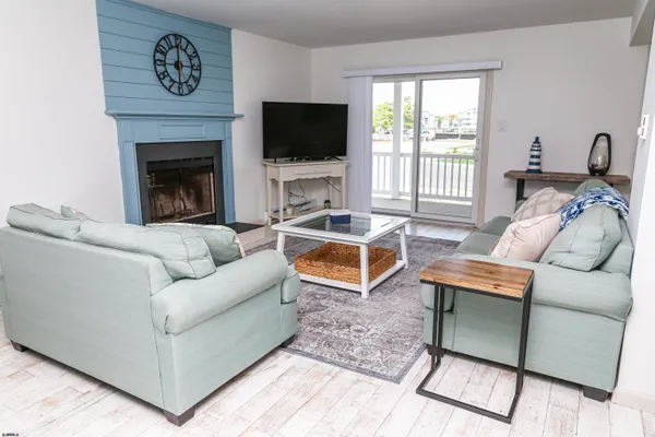 a living room with furniture a flat screen tv and a large window
