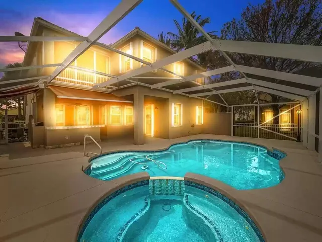 a view of a white house with a swimming pool and sitting area