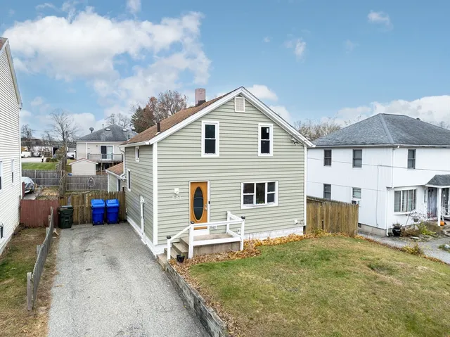 a view of a white house with a small yard and a large window