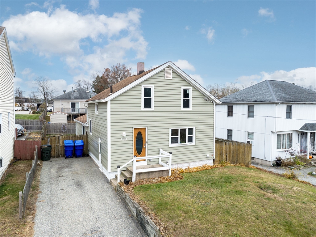 a view of a white house with a small yard and a large window