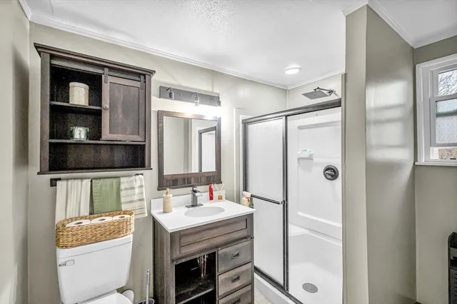 a bathroom with a sink a toilet and shower