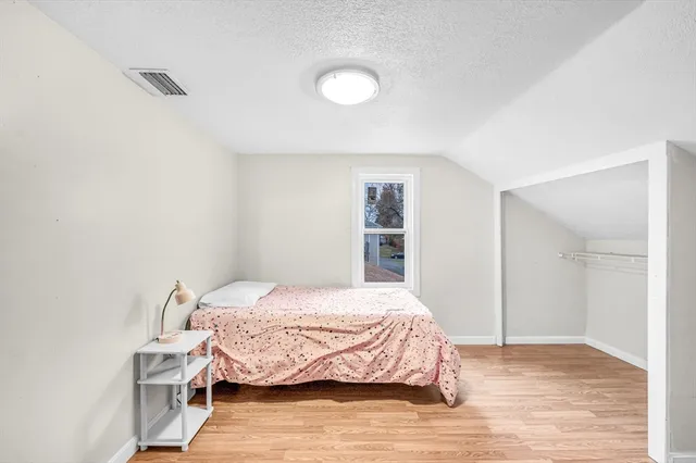 a bedroom with a bed and a window