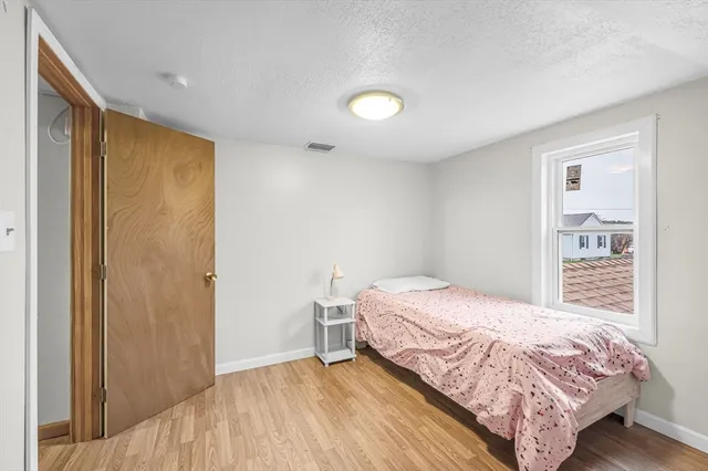a bedroom with a bed and painting on the wall