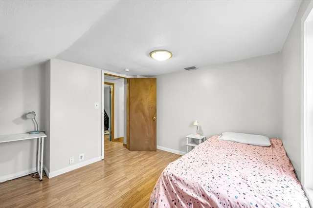 a bedroom with a bed and a refrigerator