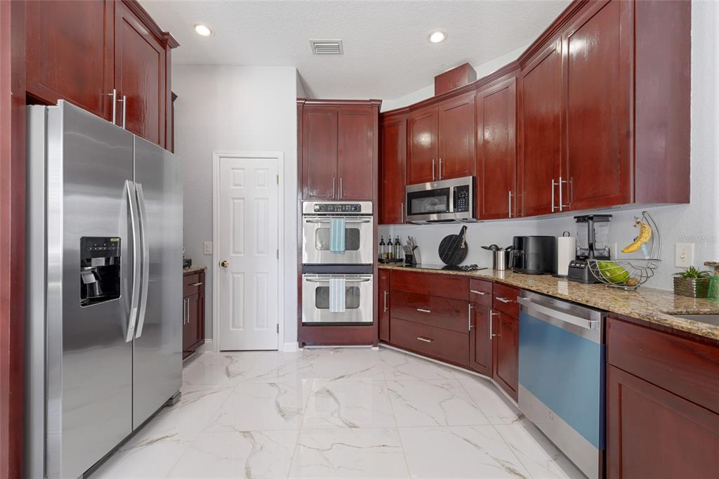 155 Hidden Woods Cove Altamonte Springs, FL 32701 - Photo 11 of 20 a kitchen with stainless steel appliances granite countertop a refrigerator and a stove top oven
