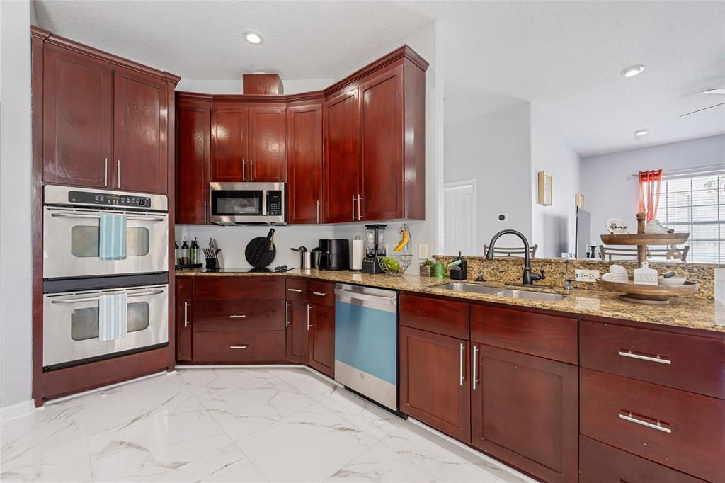 155 Hidden Woods Cove Altamonte Springs, FL 32701 - Photo 10 of 20 a kitchen with stainless steel appliances granite countertop wooden cabinets a stove top oven and granite counter tops