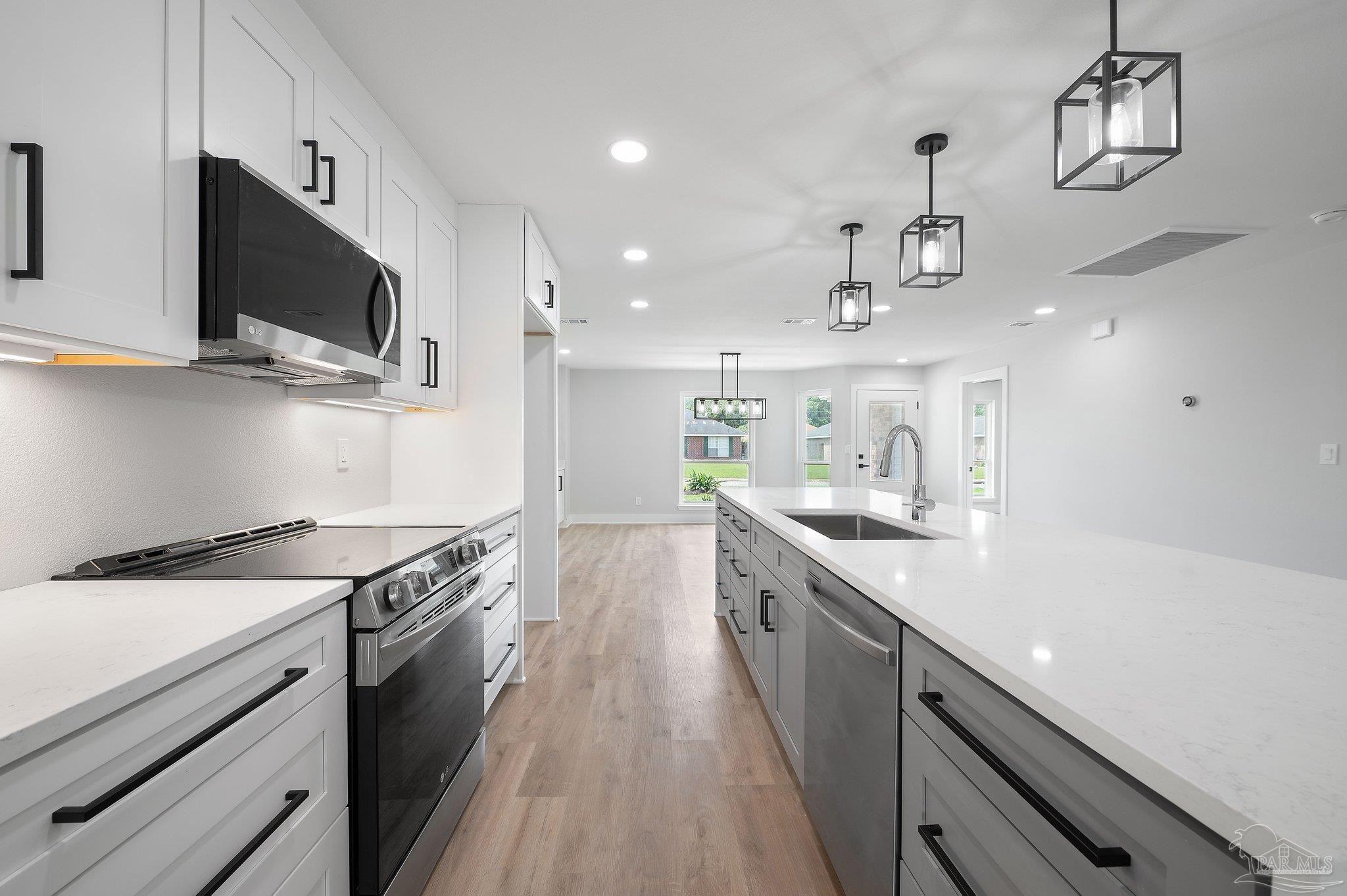 4290 Idell Lane Pace, FL 32571 - Photo 14 of 45 a kitchen with stainless steel appliances granite countertop a sink a stove top oven a counter space and cabinets