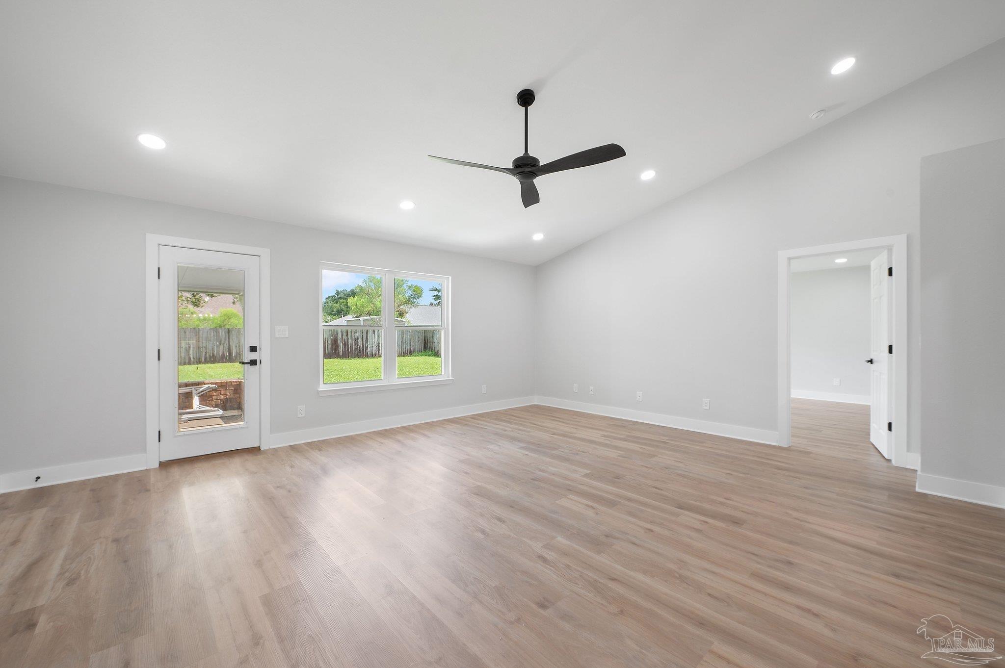4290 Idell Lane Pace, FL 32571 - Photo 16 of 45 an empty room with wooden floor ceiling fan and windows
