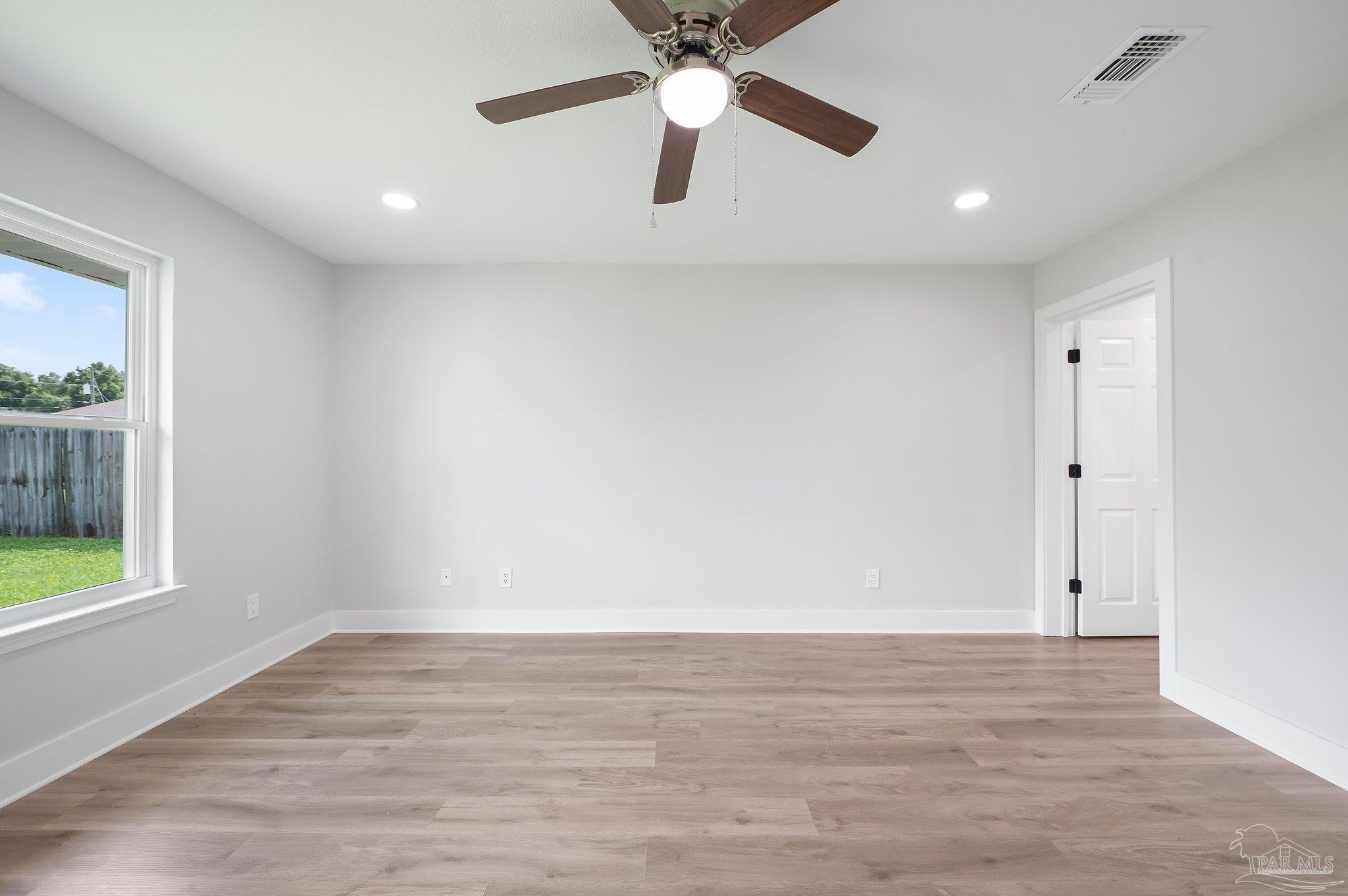 4290 Idell Lane Pace, FL 32571 - Photo 22 of 45 a view of an empty room with window and wooden floor