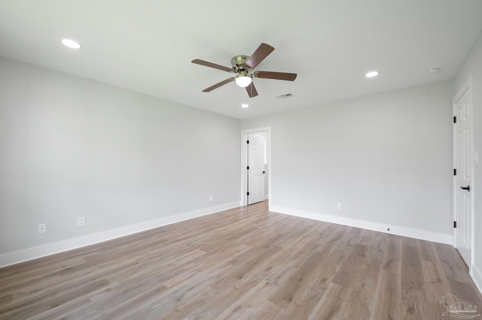 4290 Idell Lane Pace, FL 32571 - Photo 23 of 45 an empty room with wooden floor and a ceiling fan