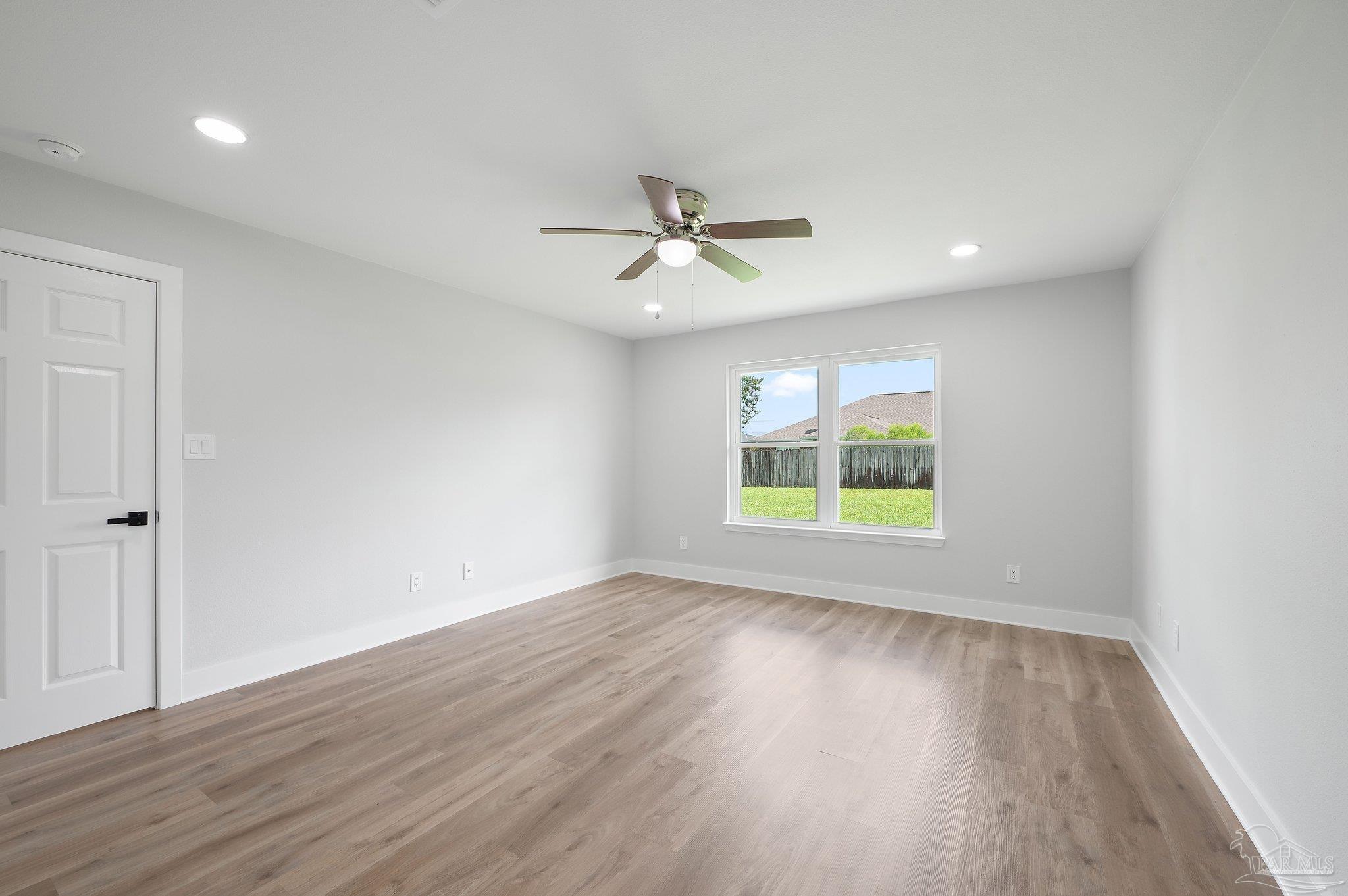4290 Idell Lane Pace, FL 32571 - Photo 24 of 45 an empty room with wooden floor and windows