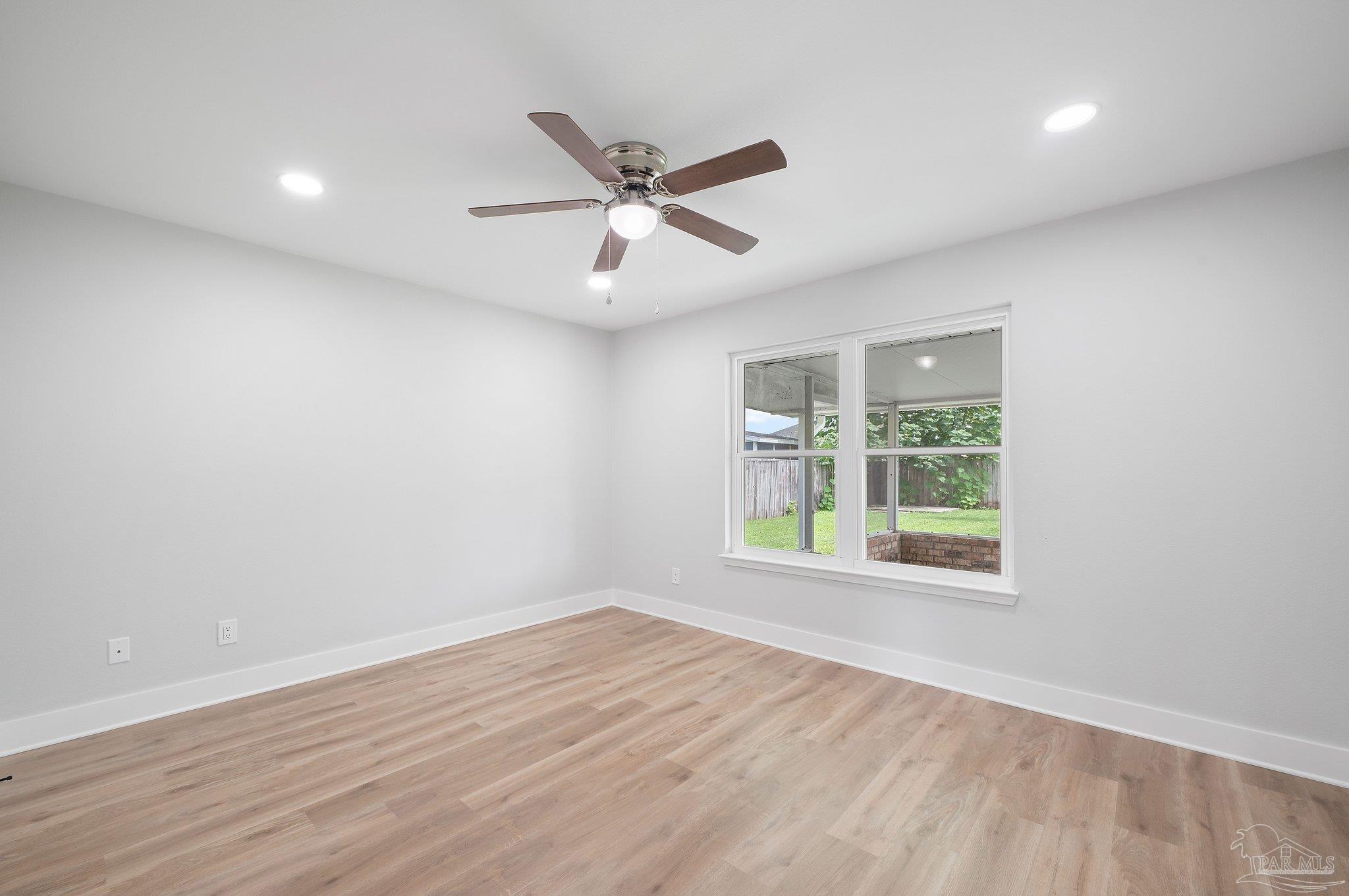 4290 Idell Lane Pace, FL 32571 - Photo 28 of 45 an empty room with wooden floor fan and windows