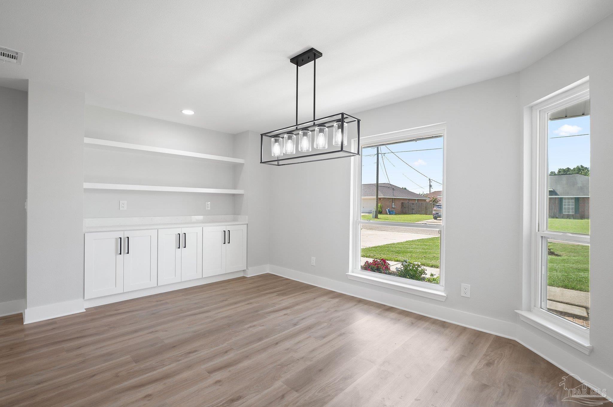 4290 Idell Lane Pace, FL 32571 - Photo 3 of 45 a view of an empty room with wooden floor and a window