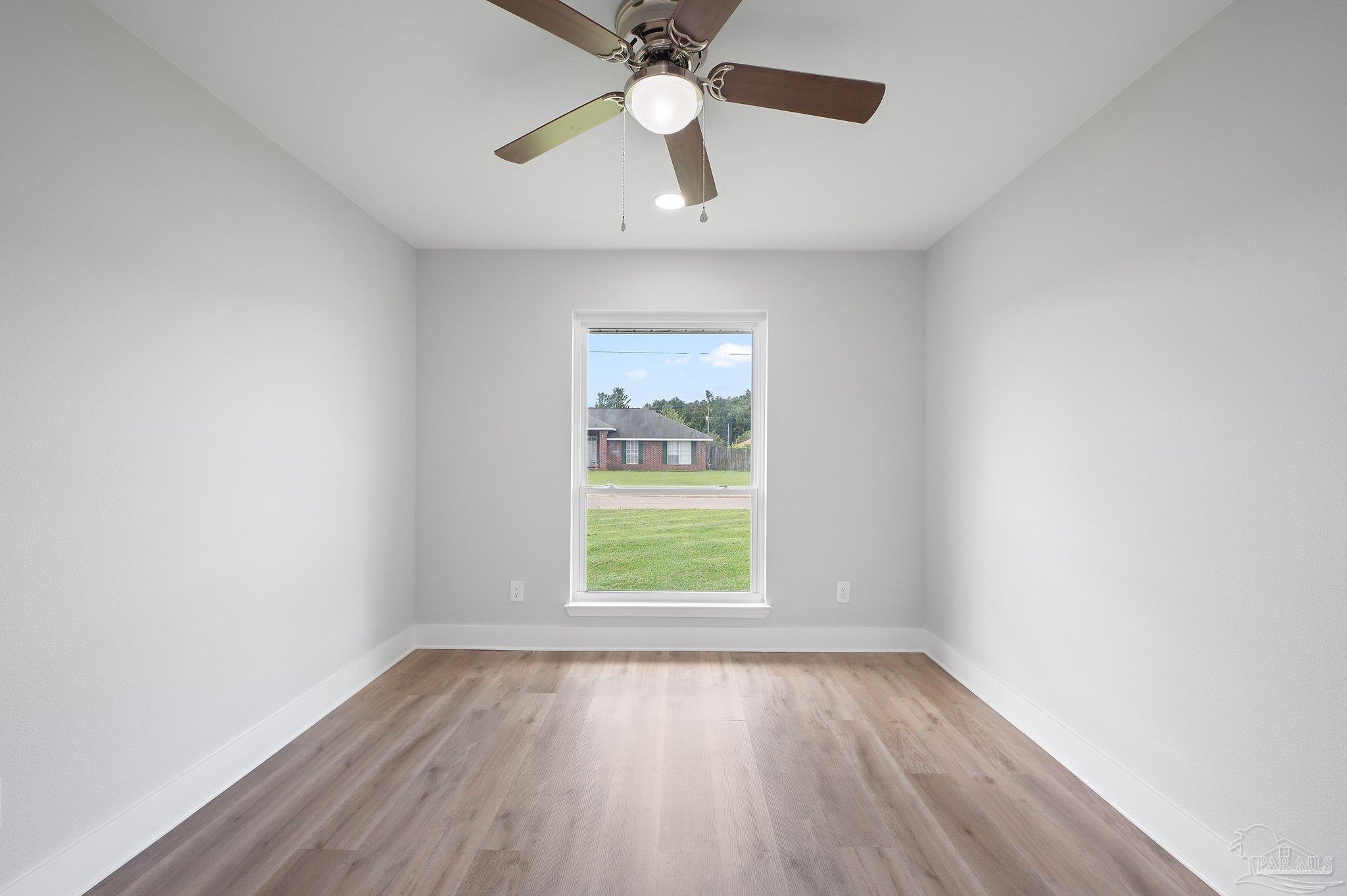 4290 Idell Lane Pace, FL 32571 - Photo 35 of 45 an empty room with wooden floor chandelier fan and windows
