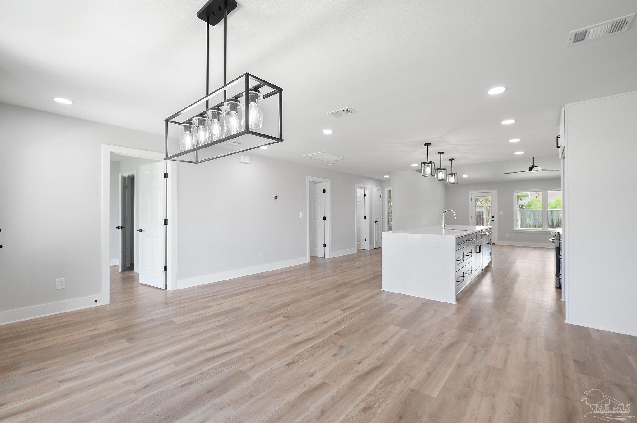 4290 Idell Lane Pace, FL 32571 - Photo 6 of 45 a view of a kitchen with wooden floor and a chandelier