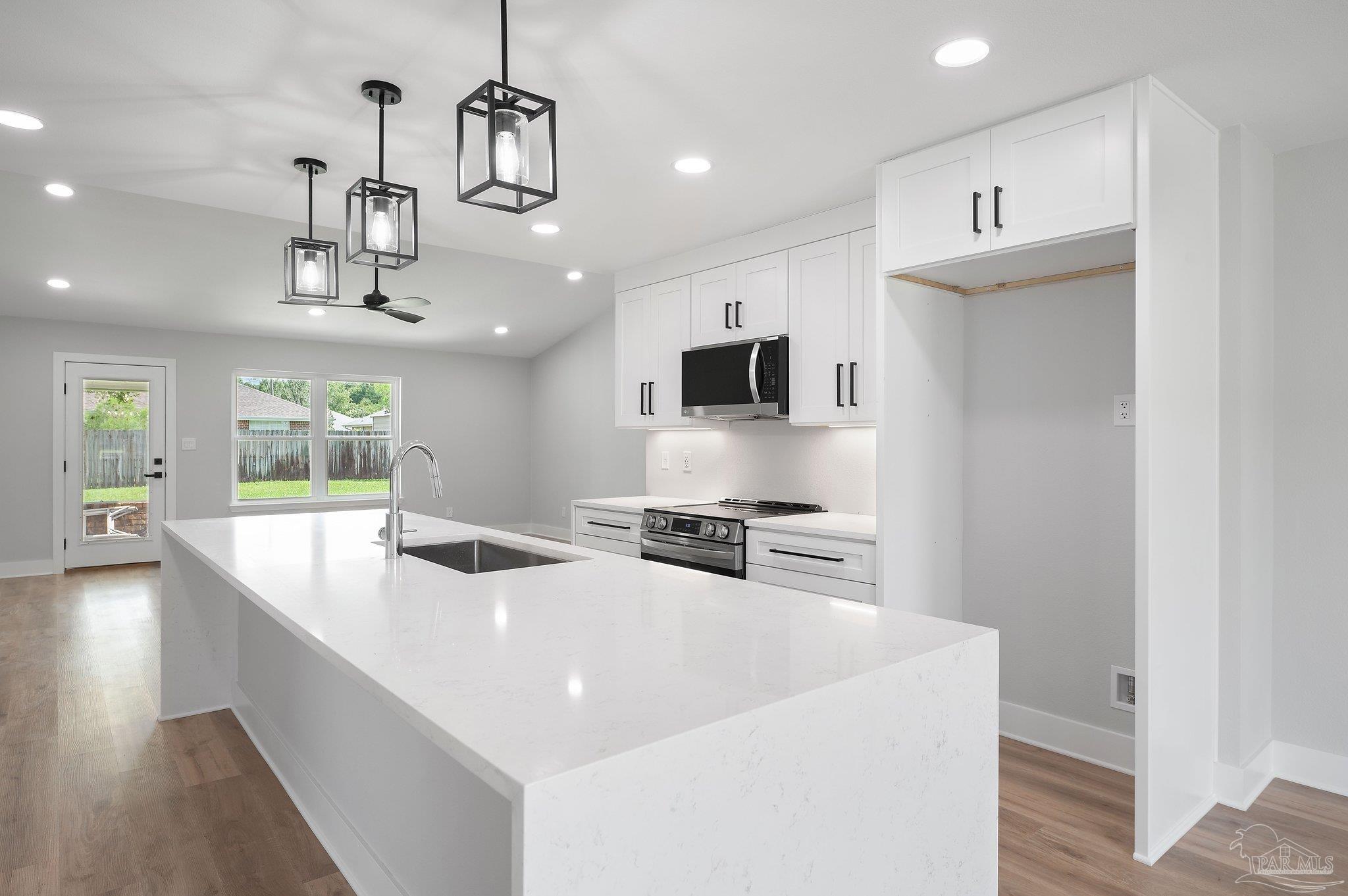 4290 Idell Lane Pace, FL 32571 - Photo 10 of 45 a kitchen with stainless steel appliances a sink a stove a refrigerator and cabinets