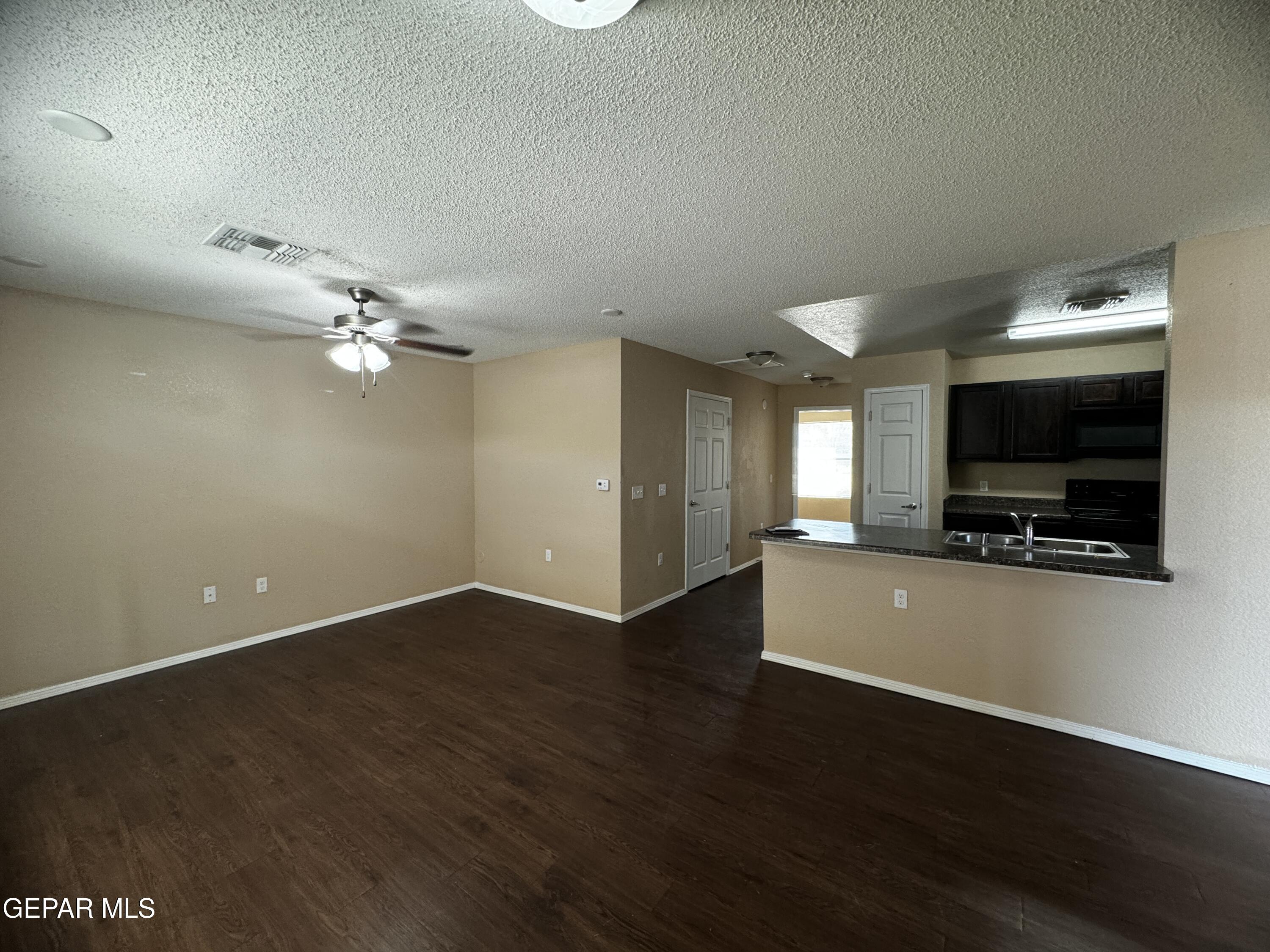 9811 Socorro Road, Unit 36 El Paso, TX 79927 - Photo 2 of 12 an empty room with wooden floor and windows