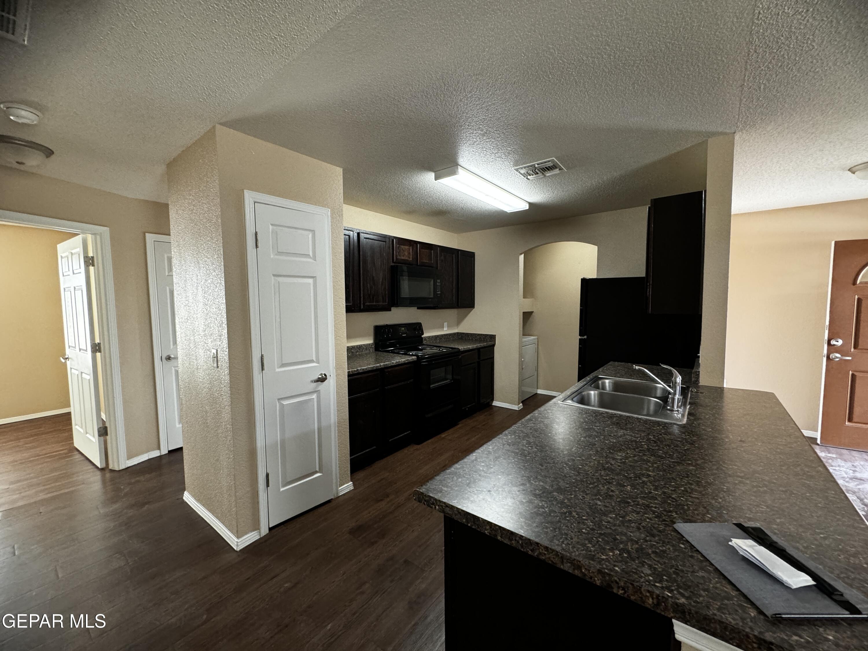 9811 Socorro Road, Unit 36 El Paso, TX 79927 - Photo 3 of 12 a kitchen with a refrigerator and a sink