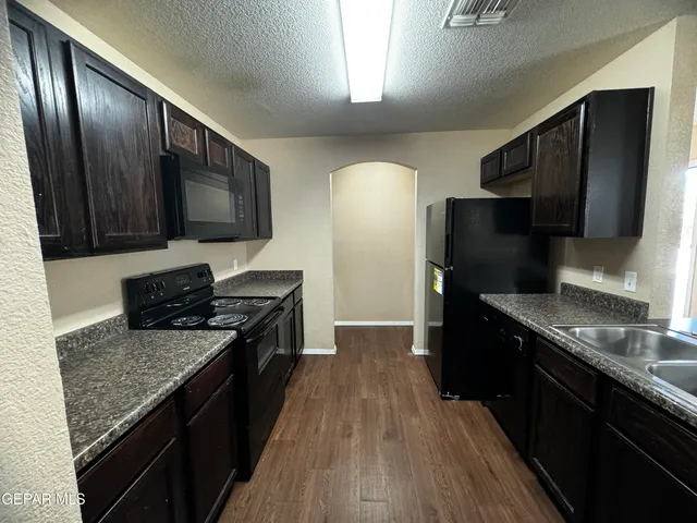 a kitchen with granite countertop stainless steel appliances and wooden cabinets