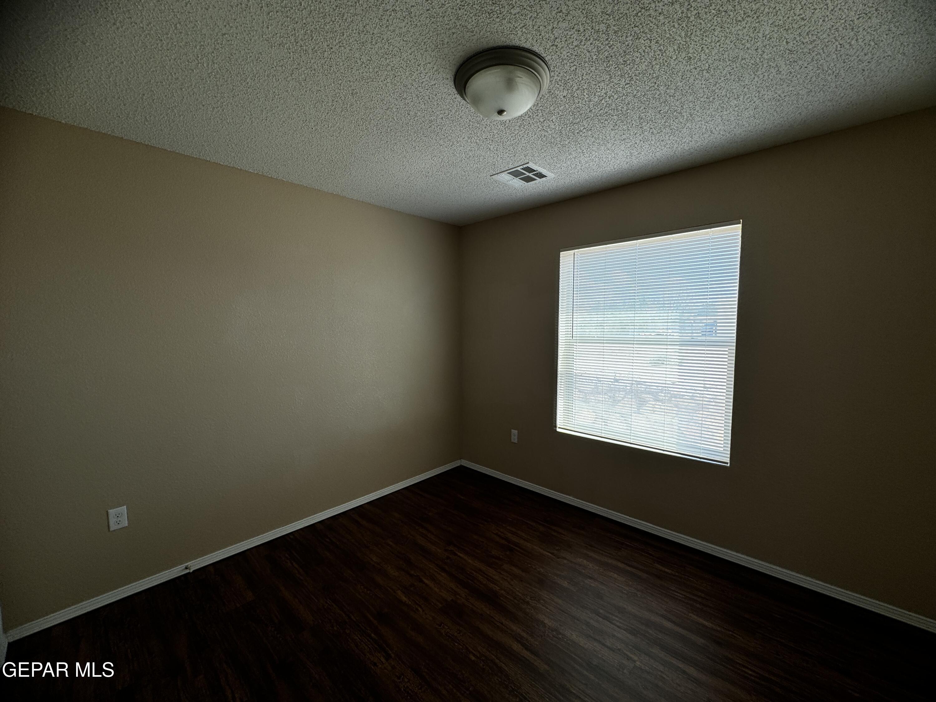 9811 Socorro Road, Unit 36 El Paso, TX 79927 - Photo 7 of 12 an empty room with wooden floor and windows