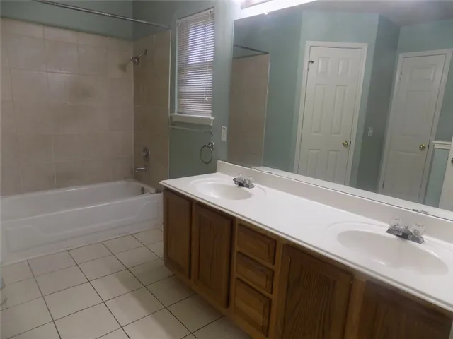 a bathroom with a bathtub sink vanity and mirror