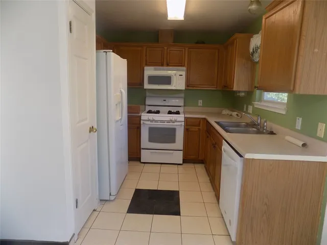a kitchen with a sink a stove and cabinets