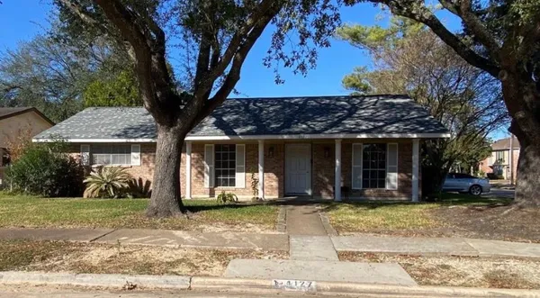 a front view of a house with a tree
