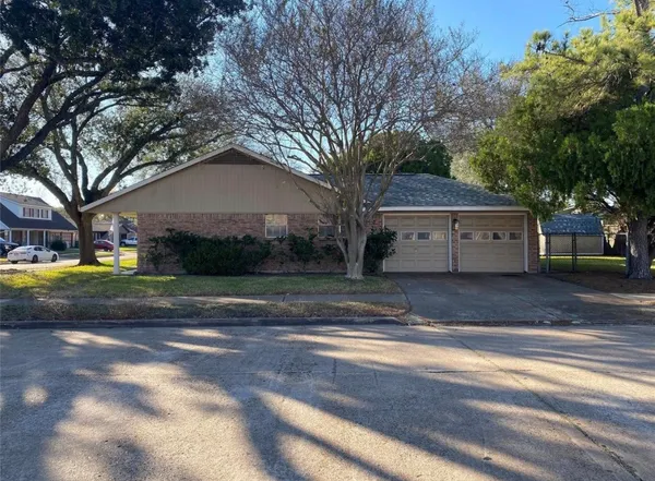 a view of a house with a yard and large tree