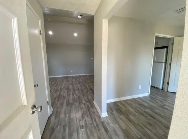 a view of a hallway with wooden floor and staircase