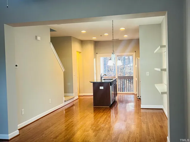 a view of a living hall with wooden floor and a large window