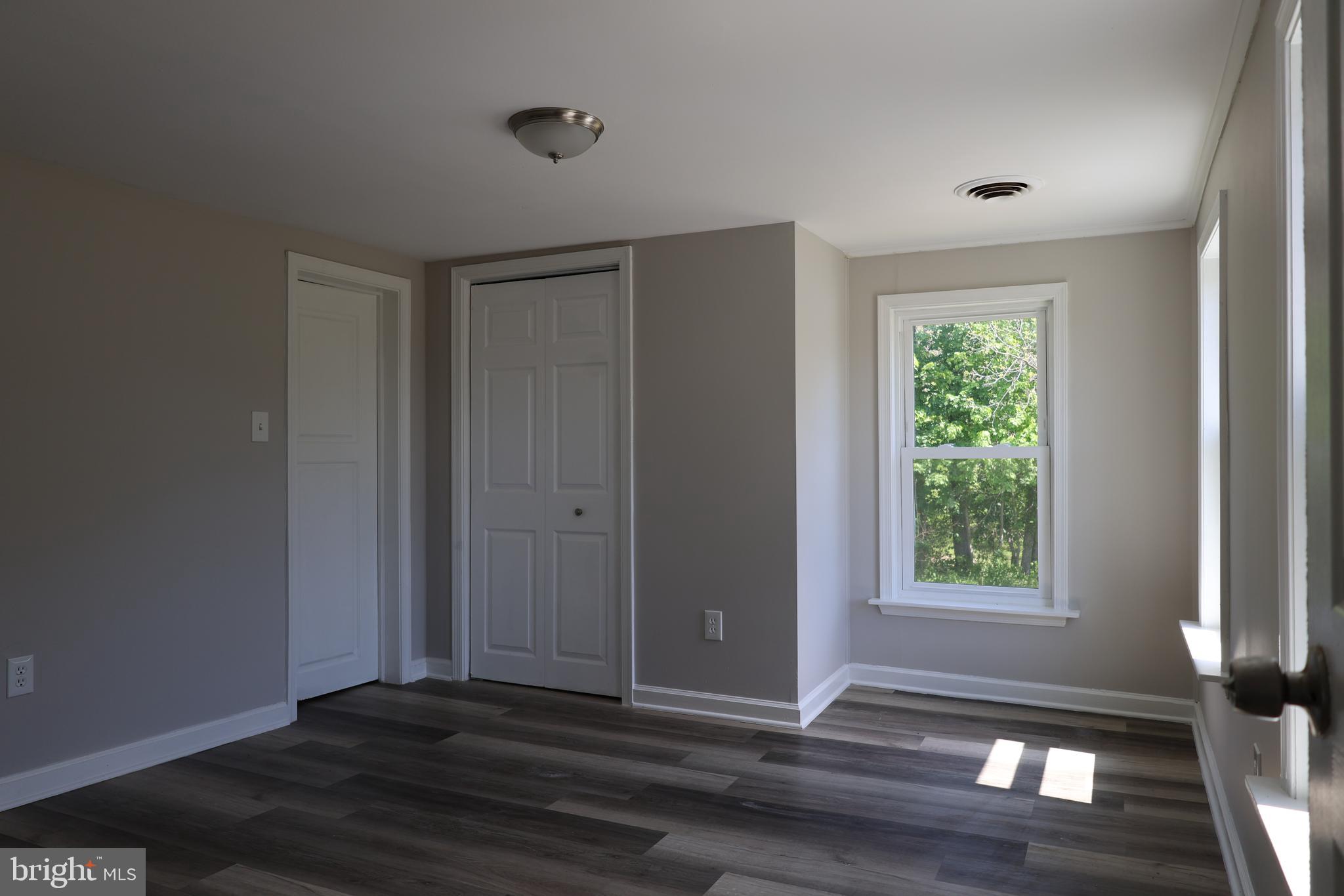 6213 Appletown Road Boonsboro, MD 21713 - Photo 16 of 18 a view of an empty room with wooden floor and a window