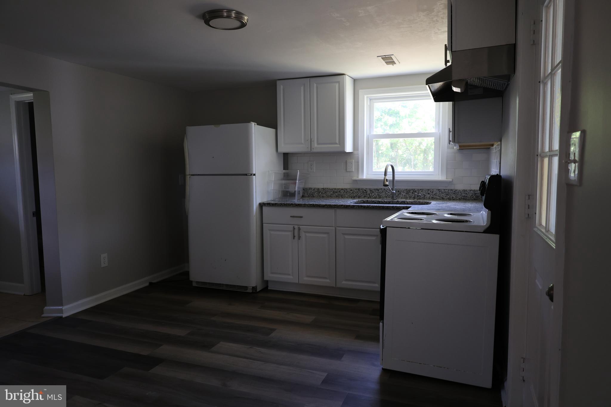 6213 Appletown Road Boonsboro, MD 21713 - Photo 8 of 18 a kitchen with a sink a refrigerator a window and cabinets
