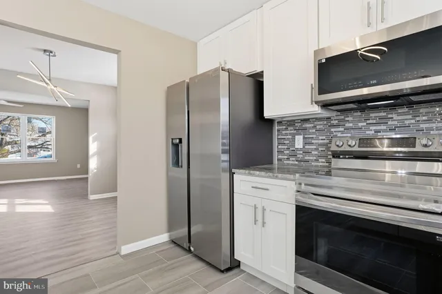 a kitchen with stainless steel appliances a stove microwave and refrigerator