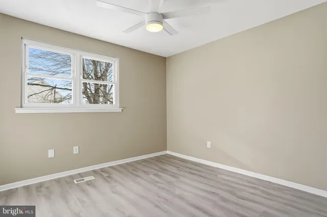 an empty room with a painting and a window