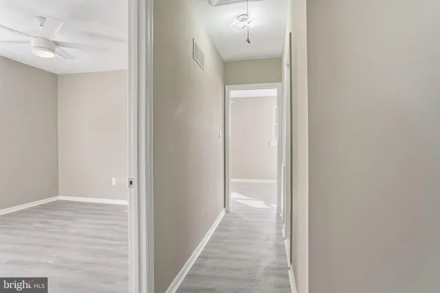 a view of a hallway with wooden floor