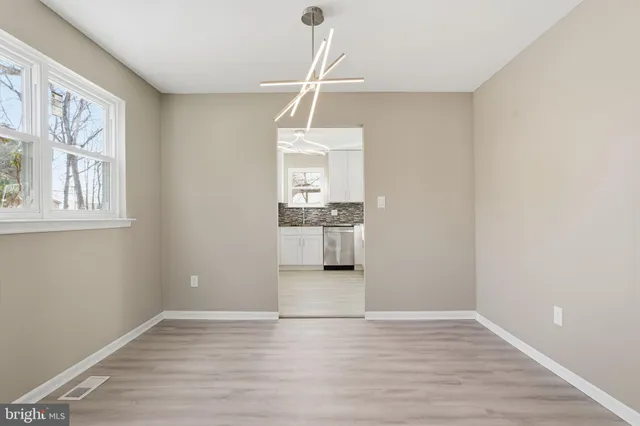 a view of a room with wooden floor and white walls