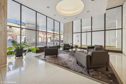 a living room with couches a coffee table and a chandelier