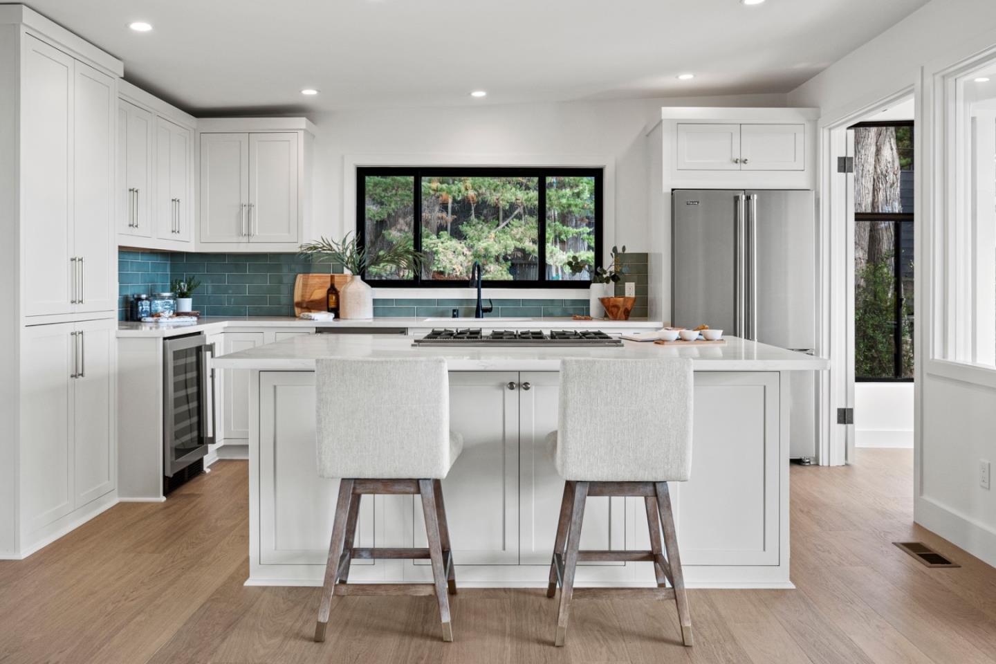 4171 Sunset Lane Pebble Beach, CA 93953 - Photo 11 of 38 a kitchen with stainless steel appliances granite countertop a stove a refrigerator a sink a stove and white cabinets with wooden floor