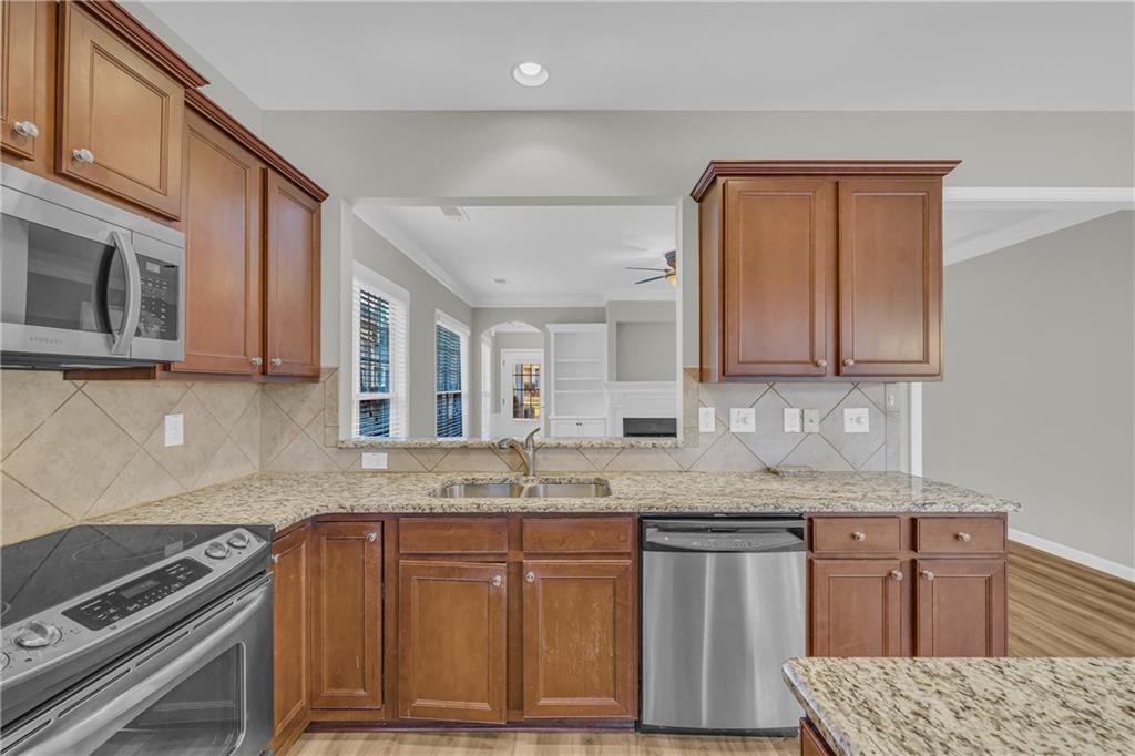 6116 Longleaf Drive Hoschton, GA 30548 - Photo 12 of 46 a kitchen with stainless steel appliances granite countertop a sink stove and microwave