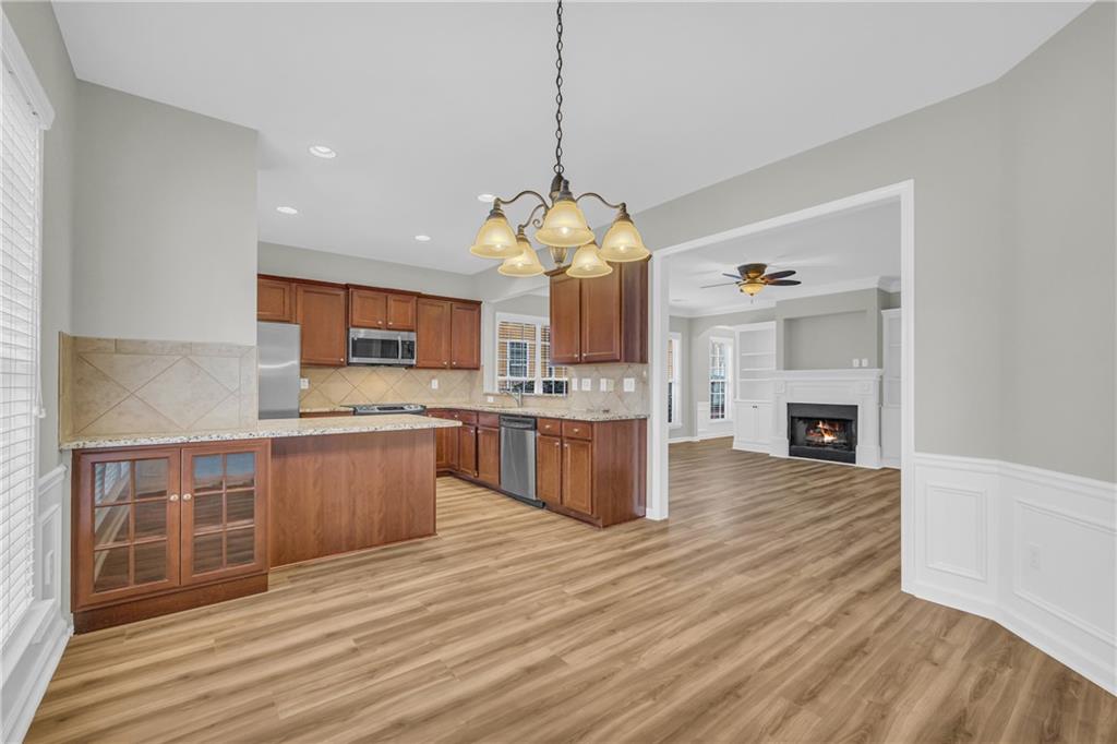6116 Longleaf Drive Hoschton, GA 30548 - Photo 13 of 46 a large kitchen with stainless steel appliances granite countertop a dishwasher a stove and a wooden floors