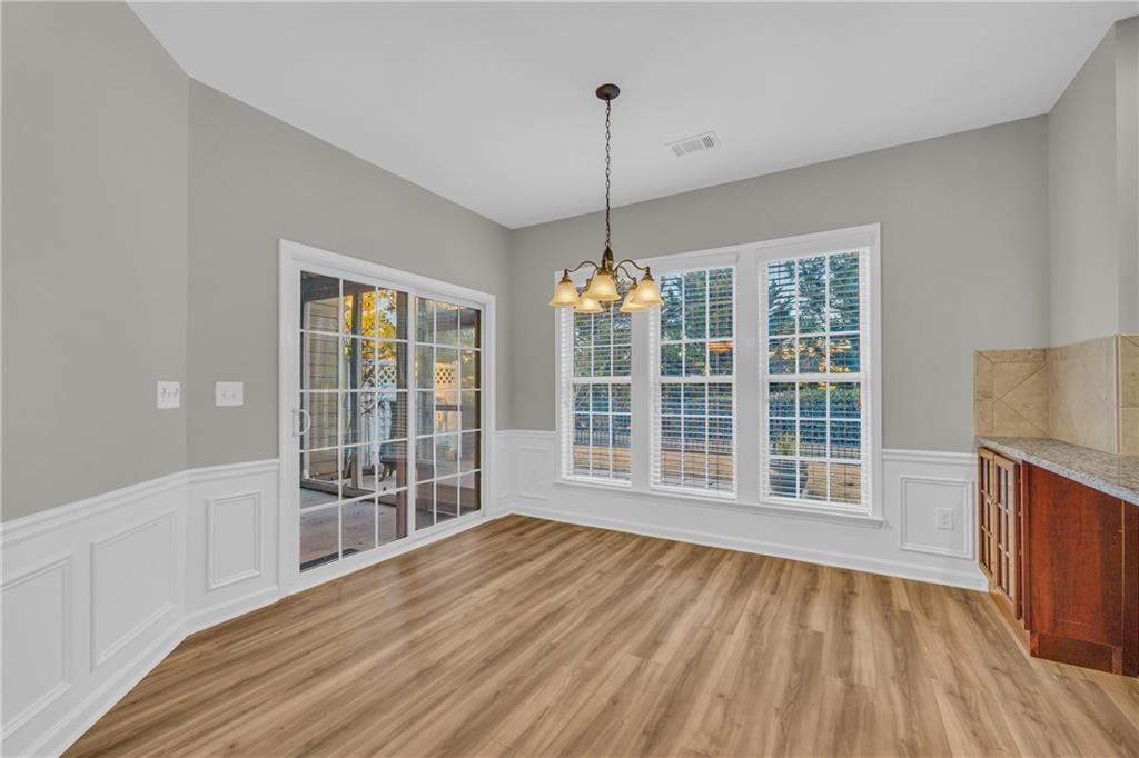 6116 Longleaf Drive Hoschton, GA 30548 - Photo 14 of 46 a view of an empty room with wooden floor and a window