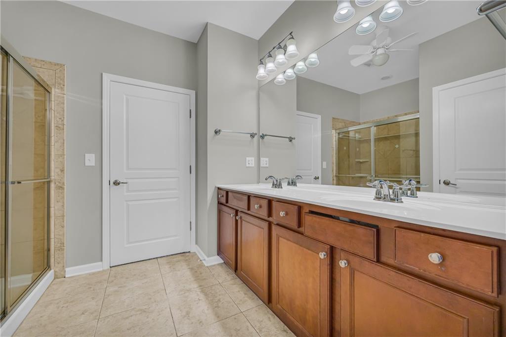 6116 Longleaf Drive Hoschton, GA 30548 - Photo 18 of 46 a spacious bathroom with a double vanity sink a large mirror and a shower